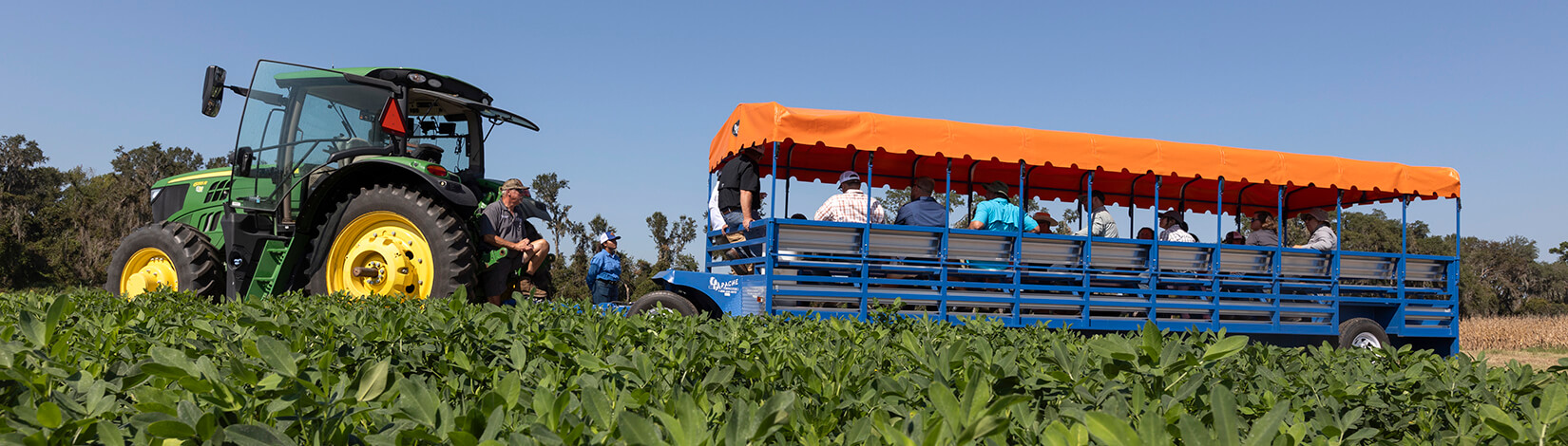 People riding in a covered vehicle to view agricultural fields